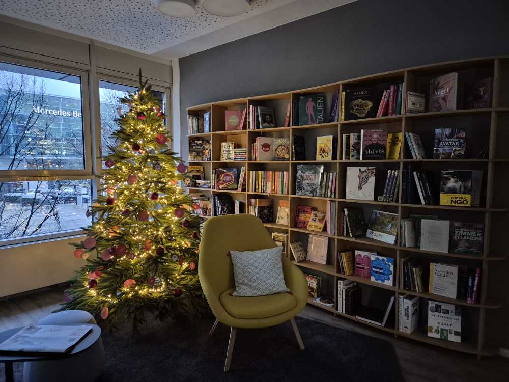 Bücherregal mit Stuhl und Weihnachtsbaum.