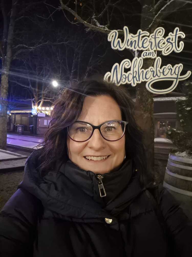 Sonja Warter vor einem Schild mit der Aufschrift "Winterfest am Nockherberg".