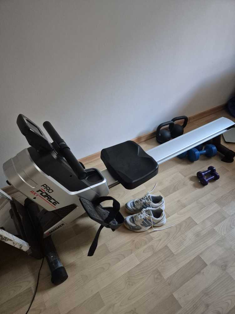 Rudergerät, Sportschuhe und Hanteln.