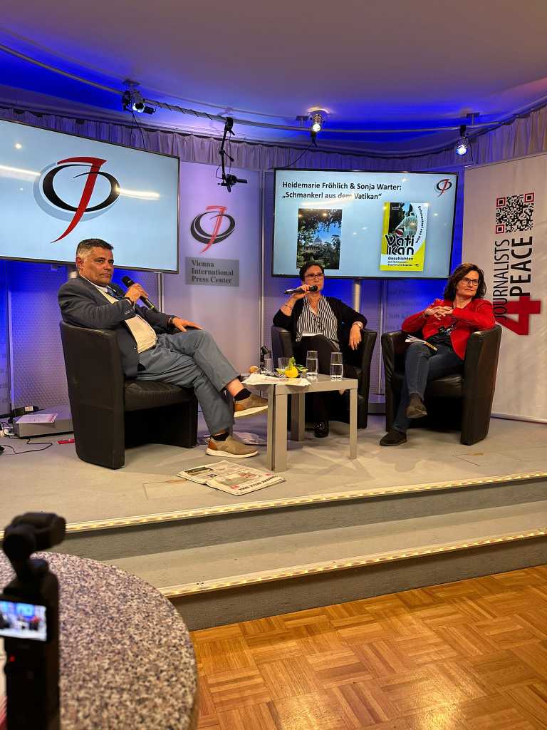 Marie Fröhlich und Sonja Warter gemeinsam mit einem Moderator im Österreichischen Journalisten Club bei einer Diskussion über ihr Buch "Schmankerl aus dem Vatikan".
