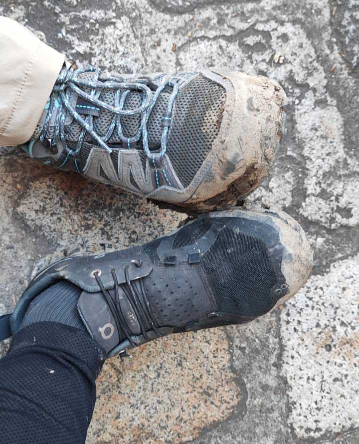 Sehr schmutzige Wanderschuhe, jeweils einer von zwei verschiedenen Personen.